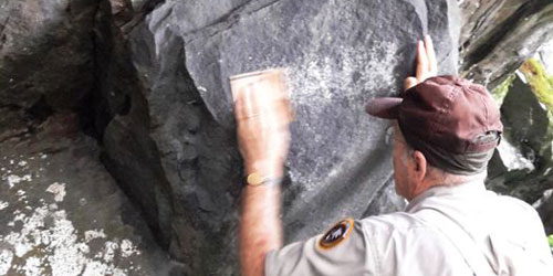 Park Ranger scrubbing paint off a boulder on Bullhead Trail
