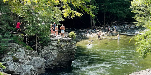 People swimming in the Little River west of The Sinks